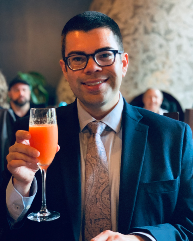 Aaron Edenshaw, founder of Inviting Eats holding peach cocktail