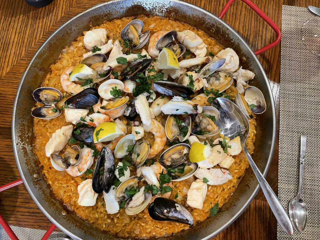 Seafood paella dish with mussels, shrimp, rice, lemons