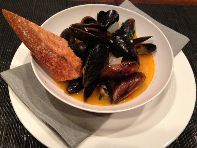 Decadent and delicious beer and harissa steamed mussels with side of bread