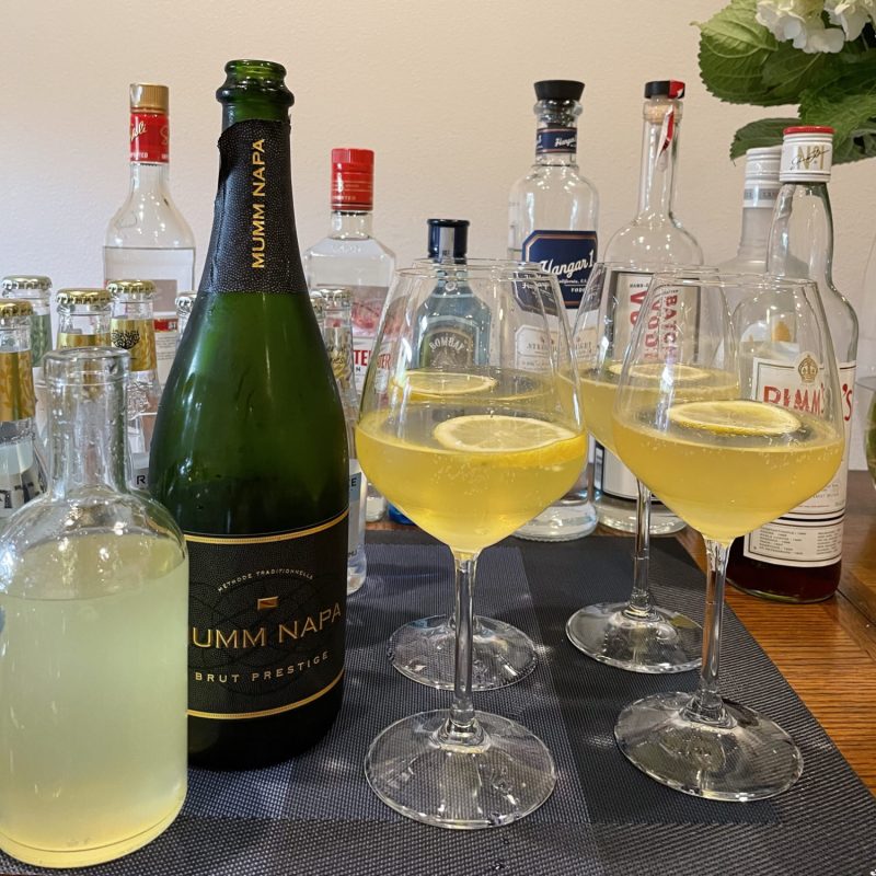 French 78 cocktail (a French 75 variation) with bottles in background